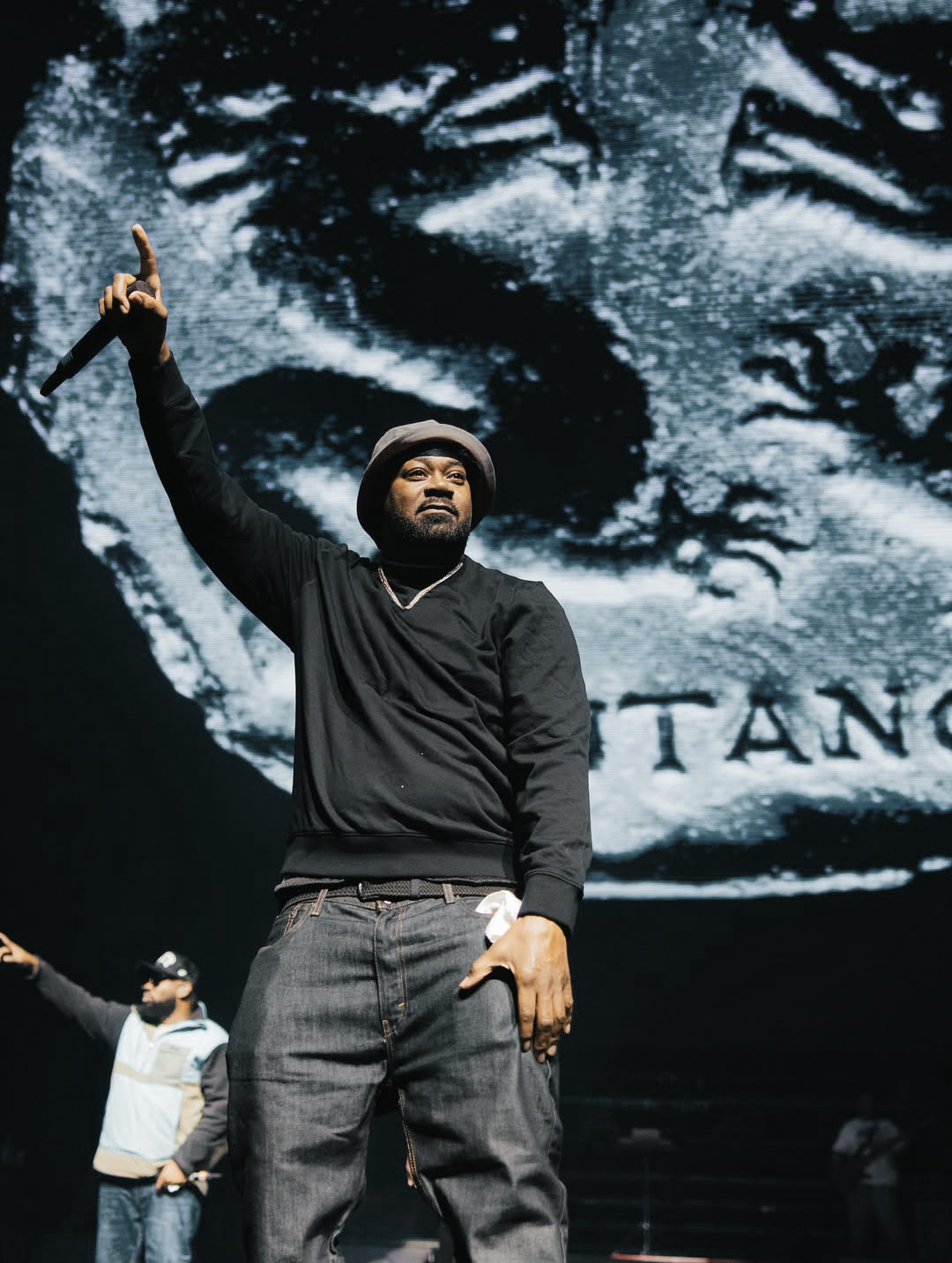 Wu-Tang — portrait sur scène devant le visuel de la pièce